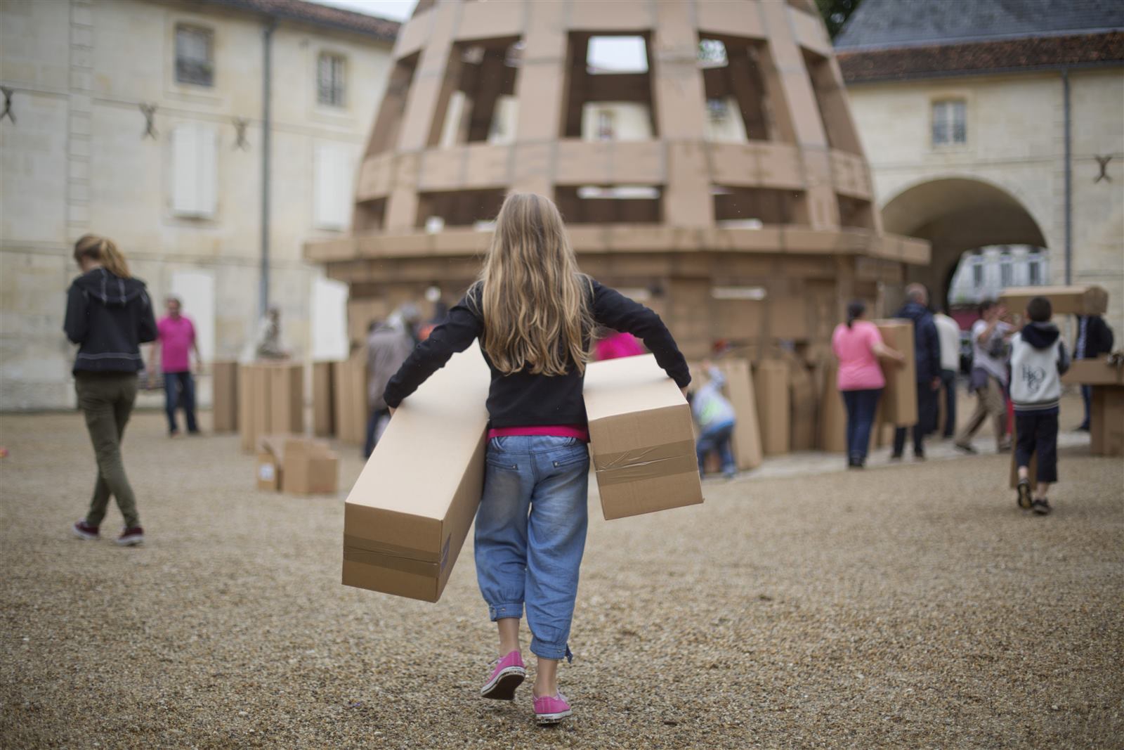 A crowd gathered in front of an enormous cardboard structure during a Lost Castles build